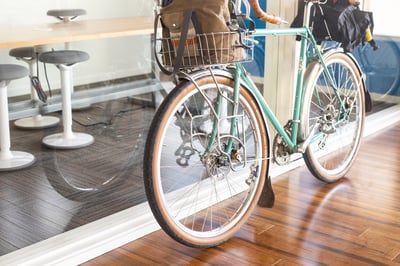 bicycle leaning against a glass wall inside an office